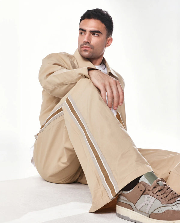 Rare Rabbit Men Macon Beige Cotton Fabric Mid Rise Baggy Fit Side Slit Tape Detailing Track Pant