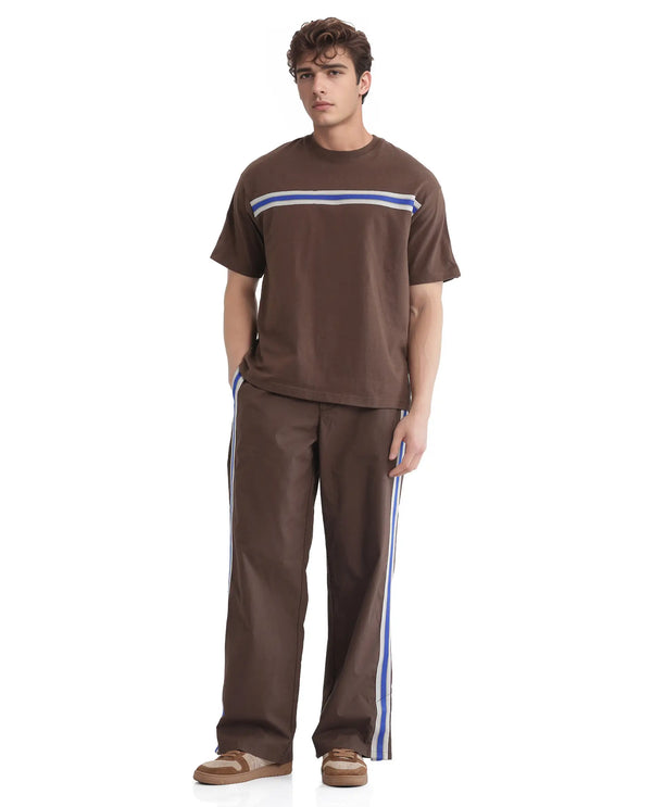 Rare Rabbit Men Newnon Brown Cotton Fabric Mid Rise Baggy Fit Side Slit with Snap Button Closure Tape Detailing Track Pant
