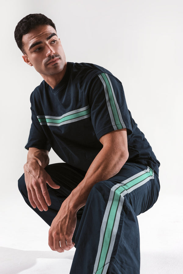 Rare Rabbit Men Newnon Navy Cotton Fabric Mid Rise Baggy Fit Side Slit with Snap Button Closure Tape Detailing Track Pant