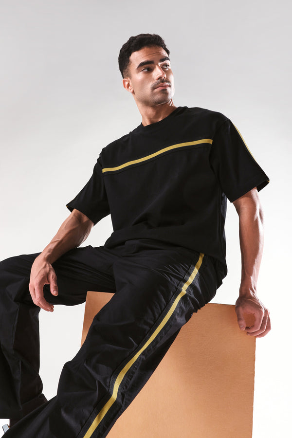Rare Rabbit Men Newnon Black Cotton Fabric Mid Rise Baggy Fit Side Slit with Snap Button Closure Tape Detailing Track Pant
